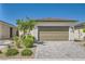 Inviting single-story home with a two-car garage, xeriscaped front yard, and stone driveway at 2110 Albury Ave, North Las Vegas, NV 89086