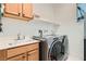 Laundry room with washer, dryer, utility sink, cabinets and shelving at 2110 Albury Ave, North Las Vegas, NV 89086