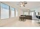 Open concept living room and dining area filled with natural light, ceiling fans, and tile floors at 2110 Albury Ave, North Las Vegas, NV 89086