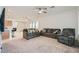 Open-concept living room offering two sofas, a ceiling fan, neutral paint, and seamless flow to the kitchen at 2110 Albury Ave, North Las Vegas, NV 89086