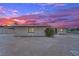 Back exterior featuring neutral color and desert landscaping against a colorful sky at 2200 Stanley Ave, North Las Vegas, NV 89030