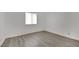 This is a bright bedroom featuring a window for natural light and modern gray floors at 2200 Stanley Ave, North Las Vegas, NV 89030