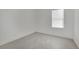 An empty bedroom showcases grey tile flooring and a window with white blinds at 2200 Stanley Ave, North Las Vegas, NV 89030