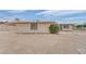 Exterior view of house showcasing barren front yard with barred windows at 2200 Stanley Ave, North Las Vegas, NV 89030
