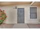 Facade of home featuring a wrought iron security door, window with security bars, and colorful flower bush at 2200 Stanley Ave, North Las Vegas, NV 89030