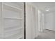 A linen closet with white shelves and bi-fold doors is in the hallway at 2200 Stanley Ave, North Las Vegas, NV 89030