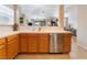 Well-lit kitchen with stainless steel dishwasher and light wood cabinets leading to the open floor plan at 2325 Windmill Pkwy # 323, Henderson, NV 89074
