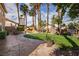 Spacious backyard with mature palm trees, lush lawn, water feature, and a charming playhouse for outdoor enjoyment at 2544 Sundew Ave, Henderson, NV 89052