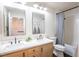 Bright bathroom features dual sinks, framed mirrors, and a tiled shower with a shower curtain at 2544 Sundew Ave, Henderson, NV 89052