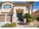 Double front doors with wreaths, desert landscaping, and two car garage at 2544 Sundew Ave, Henderson, NV 89052
