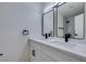 Bathroom with double vanity, black hardware, and well-lit mirrors, next to a walk-in shower at 2671 Diamante Cir, Las Vegas, NV 89121