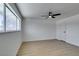 A bright, empty bedroom with a ceiling fan, light wood floors, and a large window at 2671 Diamante Cir, Las Vegas, NV 89121