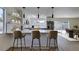 Bright kitchen with a breakfast bar, stainless steel appliances, stylish pendant lights and view into the dining room at 2671 Diamante Cir, Las Vegas, NV 89121