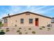 View of house's exterior backyard features desert landscaping, windows, and a back door at 2685 Crystal Blue St, Laughlin, NV 89029