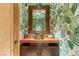 Charming powder room with botanical wallpaper, wooden framed mirror, and stylish fixtures at 3 Anthem Pointe Ct, Henderson, NV 89052