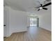 Bright living room with wood floors, a ceiling fan and sliding glass doors leading to the backyard at 3040 Carroll St, North Las Vegas, NV 89030
