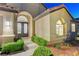 Close up of home's entryway with ornate double doors and lush, green landscaping at 3091 Via Del Corso, Henderson, NV 89052