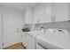Functional laundry room with white cabinets, a sink, and modern washer and dryer units at 3091 Via Del Corso, Henderson, NV 89052