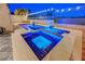 Backyard pool with jacuzzi, waterfall feature, stone patio, and exterior lighting at 3091 Via Del Corso, Henderson, NV 89052