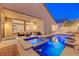 Inviting backyard pool with jacuzzi, waterfall features, stone patio, and comfortable outdoor seating at 3091 Via Del Corso, Henderson, NV 89052
