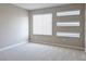 Bedroom with neutral carpet, walls, and multiple windows at 3767 Paseo De Paz Ave, Las Vegas, NV 89115