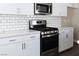 Modern kitchen with stainless steel gas range, white countertops and white subway tile backsplash at 3767 Paseo De Paz Ave, Las Vegas, NV 89115