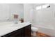 Bathroom featuring a white sink and dark wood cabinets, mirror, and tiled shower at 3934 Sangre De Cristo Ave, Las Vegas, NV 89118