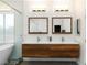 Modern bathroom featuring double sinks, sleek wood cabinets, and a glass-enclosed shower at 3934 Sangre De Cristo Ave, Las Vegas, NV 89118