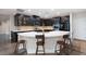 Spacious kitchen with an island featuring bar seating and dark cabinets paired with white countertops at 3934 Sangre De Cristo Ave, Las Vegas, NV 89118