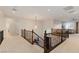Open loft area with wrought iron railing, decorative lighting, and neutral carpeting at 3934 Sangre De Cristo Ave, Las Vegas, NV 89118