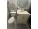 Tiled bathroom features a single sink vanity and toilet with storage above at 4030 E Carey Ave, Las Vegas, NV 89115