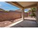 View of the covered patio and brick wall in the backyard at 4140 Gliding Gulls Ave, North Las Vegas, NV 89084