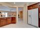 Kitchen featuring hardwood cabinets, white refrigerator, and tile floors at 4140 Gliding Gulls Ave, North Las Vegas, NV 89084