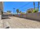 Large backyard with gravel landscaping, mature trees, covered patio, and a block wall perimeter at 417 Wisteria Ave, Las Vegas, NV 89107