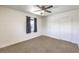 Bright bedroom features neutral carpet, a ceiling fan, window with curtain, and ample closet space at 417 Wisteria Ave, Las Vegas, NV 89107
