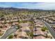 Expansive aerial view of a neighborhood with well-maintained homes, lush landscaping, and a golf course in the background at 435 Piute Valley Ct, Henderson, NV 89012