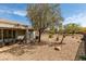 Exterior home backyard featuring mature shade trees, patio with furniture, and desert landscaping with rock ground cover at 435 Piute Valley Ct, Henderson, NV 89012