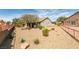 Home's backyard with desert landscaping featuring mature shade trees and bushes with a rock ground cover at 435 Piute Valley Ct, Henderson, NV 89012