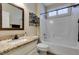 Well-lit bathroom featuring granite countertop vanity, decorative mirror and a shower-over-tub with white tiled walls at 435 Piute Valley Ct, Henderson, NV 89012