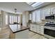 Bright kitchen features a center island with butcher block top, white cabinetry, and stainless steel appliances at 435 Piute Valley Ct, Henderson, NV 89012
