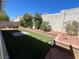 Backyard boasting a well-manicured artificial lawn, patio area, and mature shrubs at 4411 Wild Honey Ct, Las Vegas, NV 89147