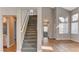 The entryway showcases an impressive staircase, tile floors, and an abundance of natural light from large windows at 4411 Wild Honey Ct, Las Vegas, NV 89147