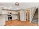 Well-lit kitchen with staircase, stainless appliances, and tile floors at 4411 Wild Honey Ct, Las Vegas, NV 89147