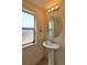 Powder room with pedestal sink, oval mirror, and frosted window with natural light at 4905 Quiet Morning St, Las Vegas, NV 89122