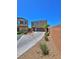 Front exterior view of home with desert landscaping, driveway, and brick perimeter wall at 4905 Quiet Morning St, Las Vegas, NV 89122