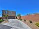 Two story home with large driveway, desert landscaping, and two car garage at 4905 Quiet Morning St, Las Vegas, NV 89122