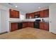 Well-lit kitchen featuring modern black appliances, granite countertops, and sleek wood cabinetry at 4905 Quiet Morning St, Las Vegas, NV 89122