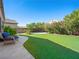 Enjoy this serene backyard with artificial grass, mature trees, and privacy, perfect for relaxation or entertaining at 5521 Moss Landing St, North Las Vegas, NV 89031
