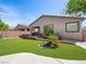 Well-maintained backyard with green grass, a covered patio, and lush landscaping at 5521 Moss Landing St, North Las Vegas, NV 89031