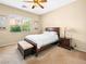 Well-lit bedroom with a cozy bed, a ceiling fan, a window overlooking the outdoor landscape at 5521 Moss Landing St, North Las Vegas, NV 89031